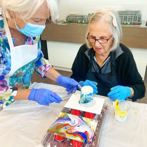 two women creating art with alcohol ink paint 